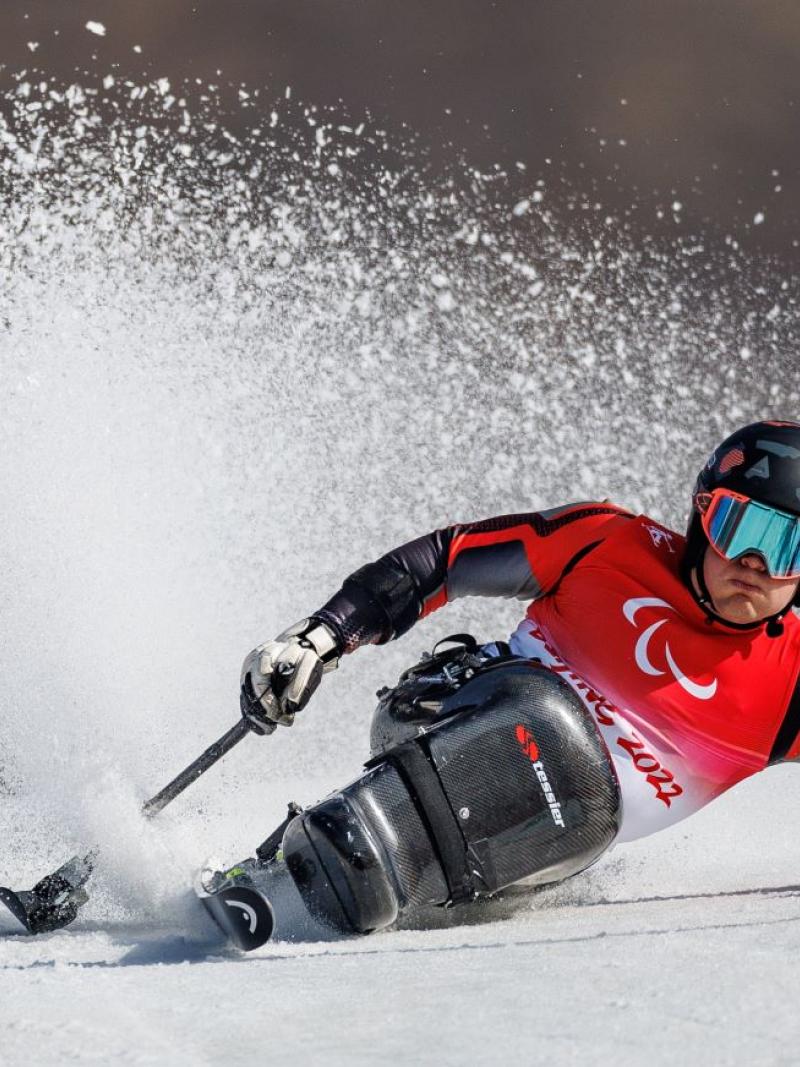 A male athlete competes on a sit-ski.