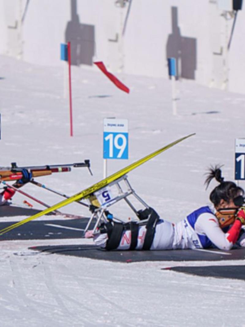 Two female athletes in a Para biathlon shooting range