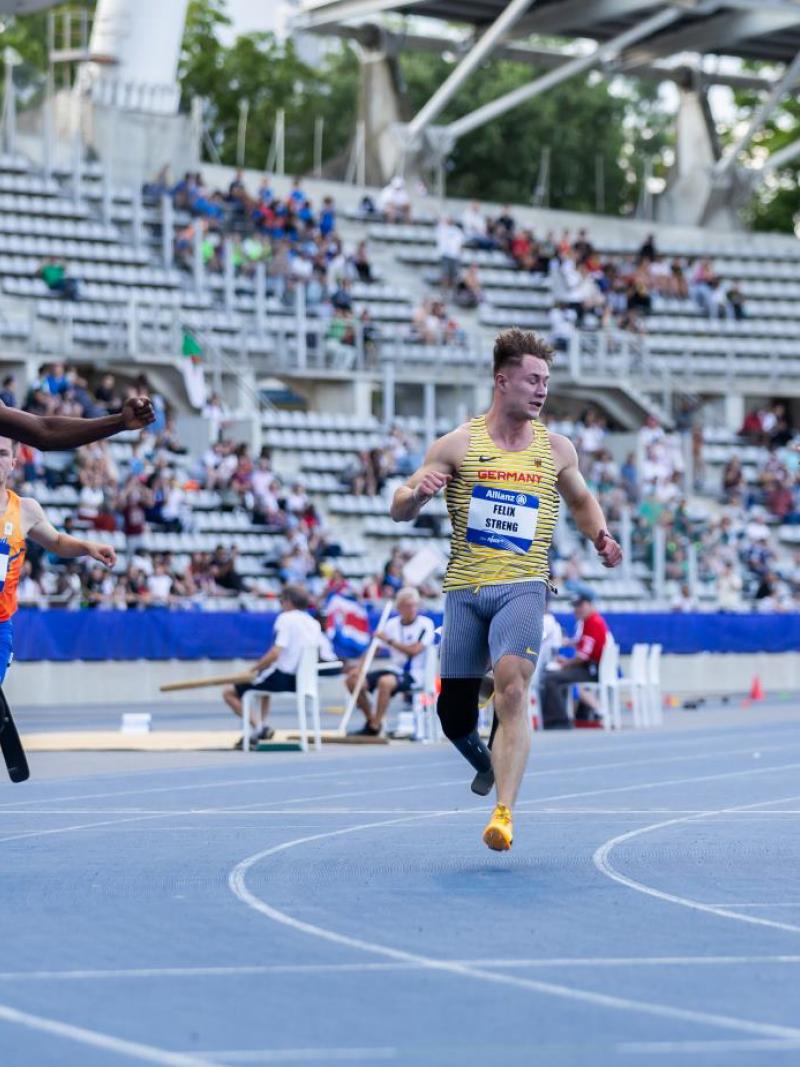 Three male blade runners in a Para athletics race
