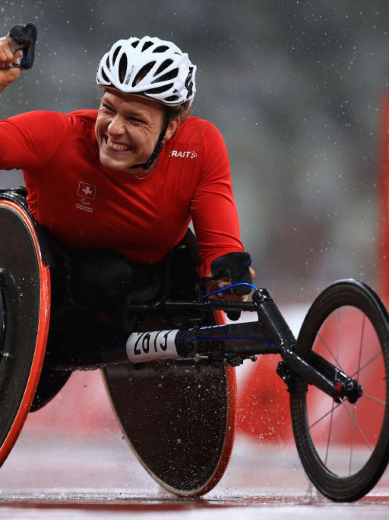 Wheelchair racer Catherine Debrunner celebrates winning with her fist raised in the air
