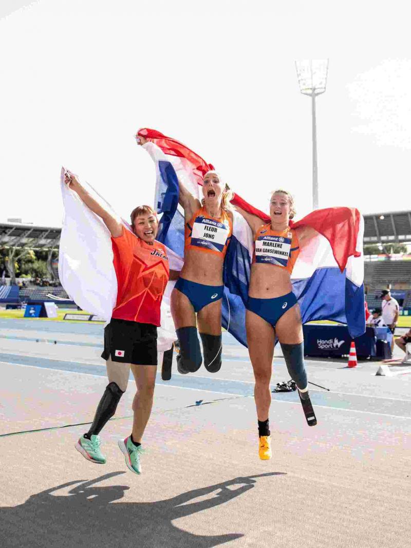 Three female athletes with prosthetic legs jumping