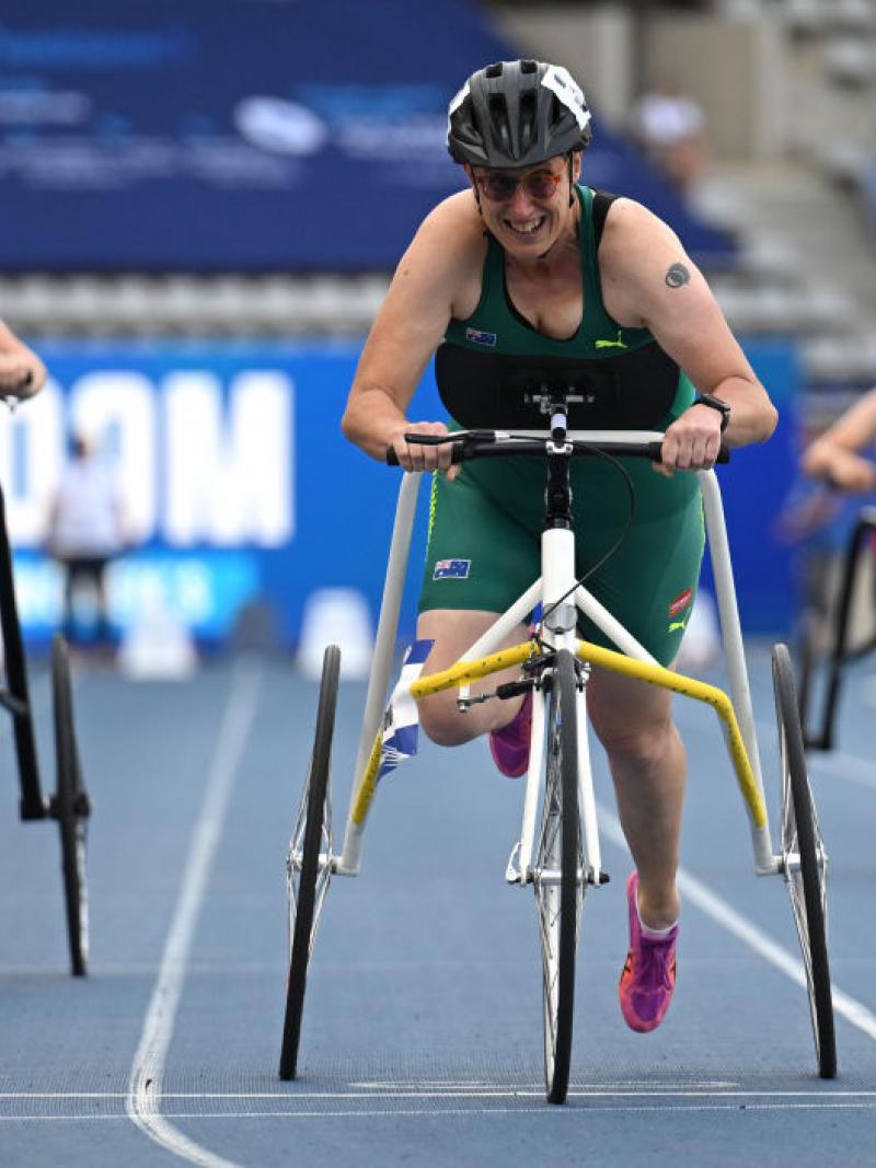 Three female athletes running with a frame on the track