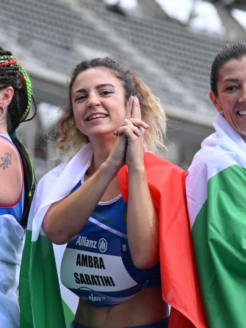 Martina Caironi, Ambra Sabatini, Monica Graziana posing together wrapped in the Italian flag