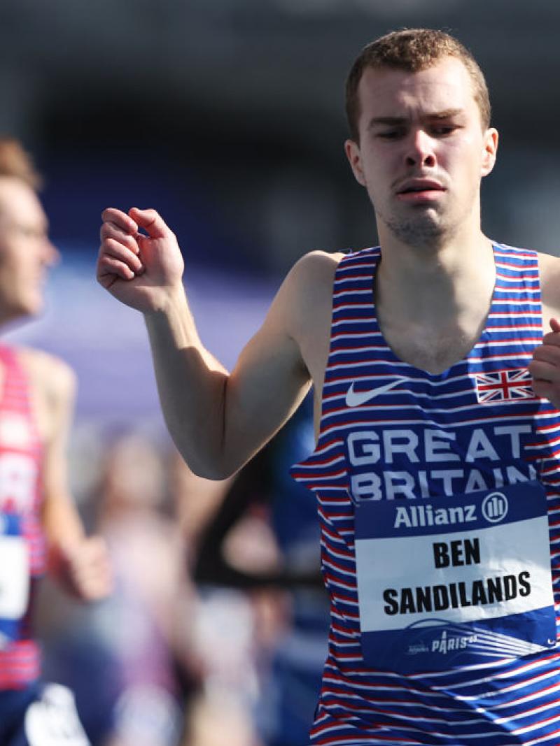 A male runner ahead of other runners in a competition