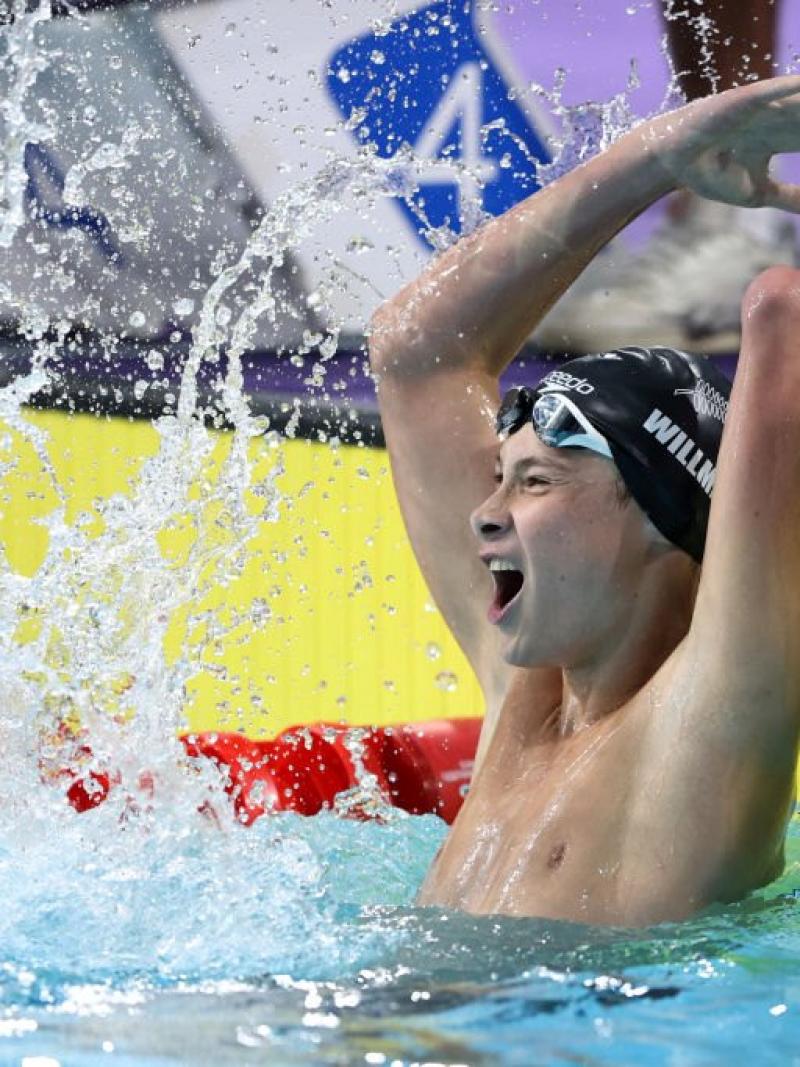 A young armless male swimmer celebrating in the pool