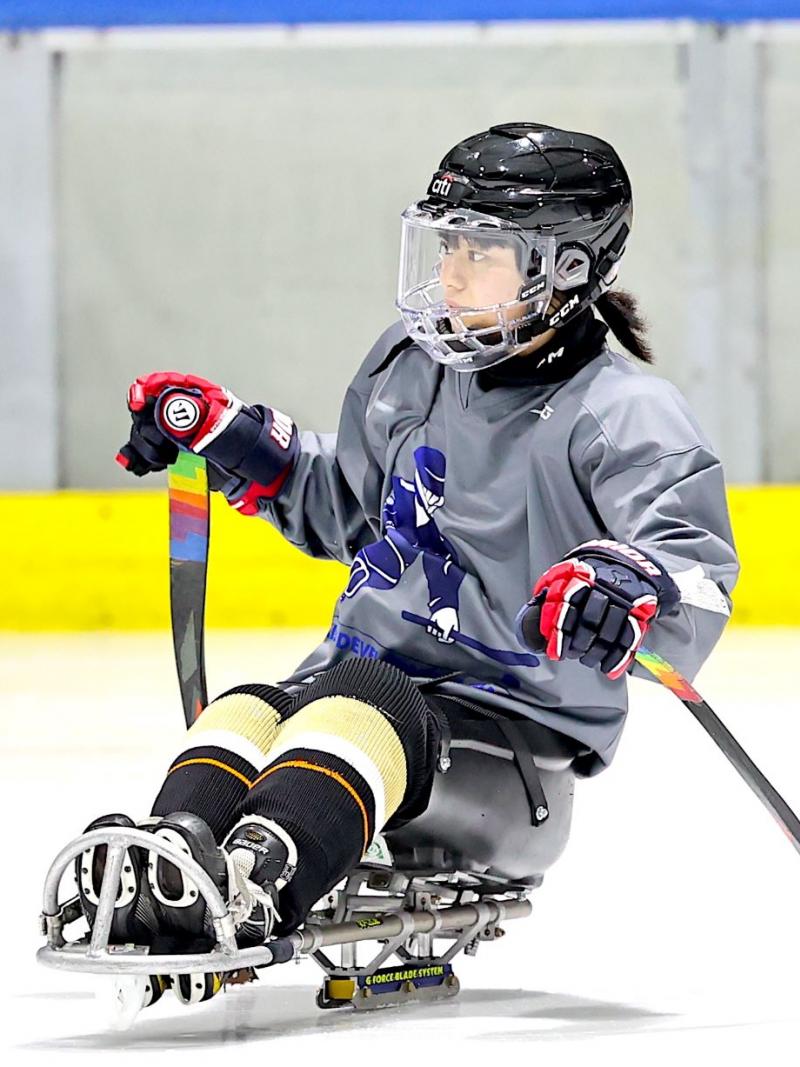 A female Para ice hockey player on a rink