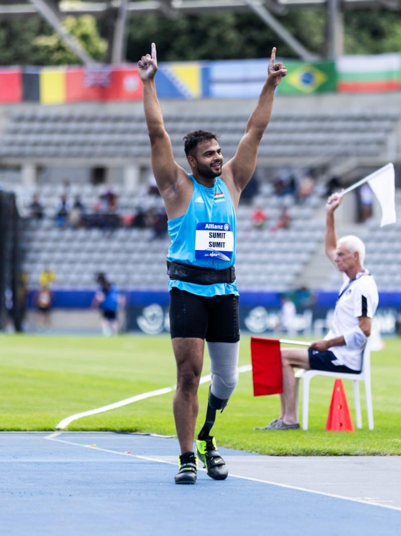 A men with a prosthetic leg celebrating on an athletics track