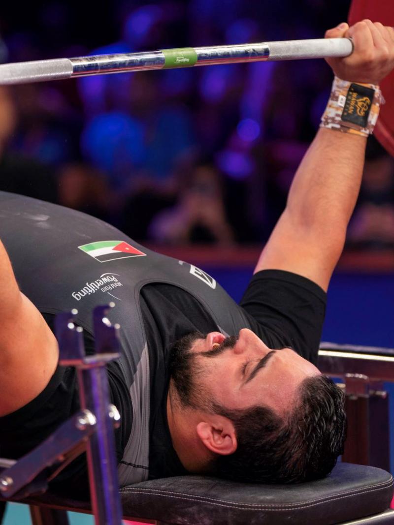 A man lifting a bar on a bench press
