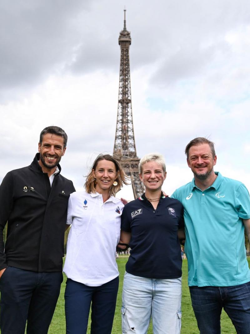 Four people pose for a photo in front of the Eiffel Tower