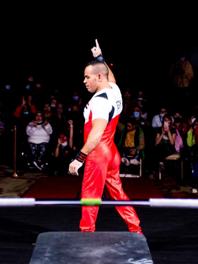 A male powerlifter standing in front of the crowd during a competition