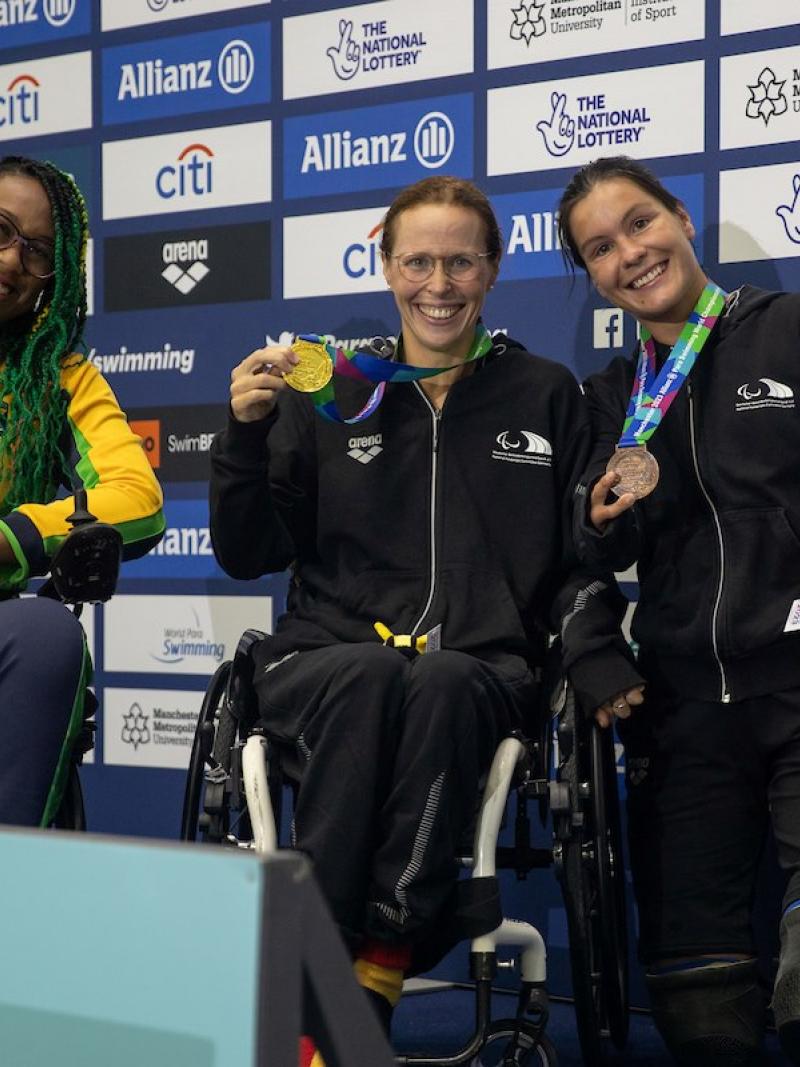 Three women on a podium with their medals