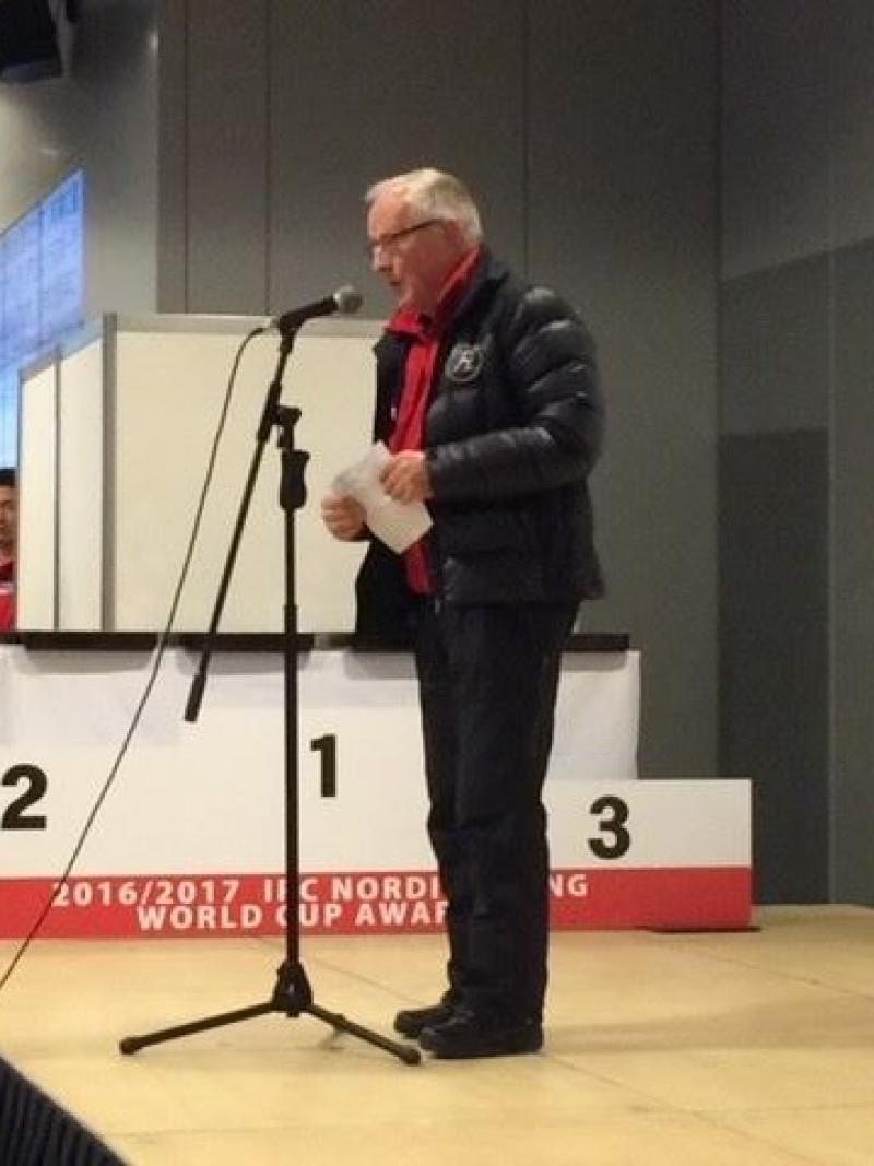 a man standing on a stage speaking into a microphone