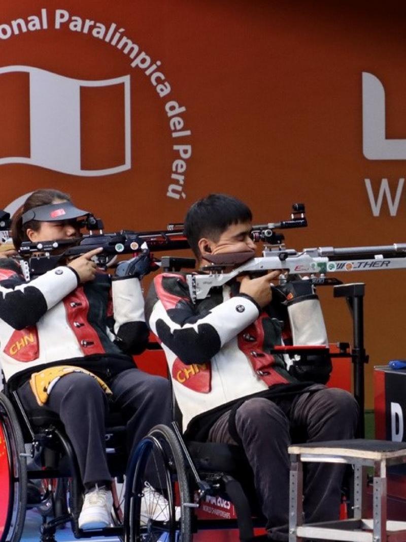 Four rifle shooters in wheelchairs in a shooting range