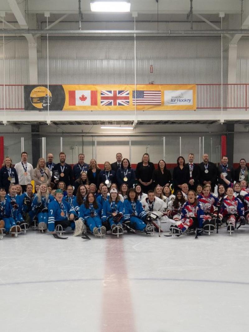 Four women's Para ice hockey teams posing for a picture on an ice rink