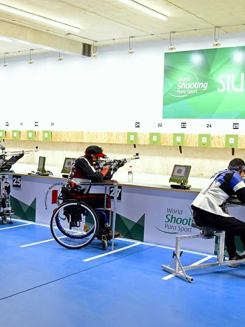 Five shooters competing in a rifle event in a shooting range