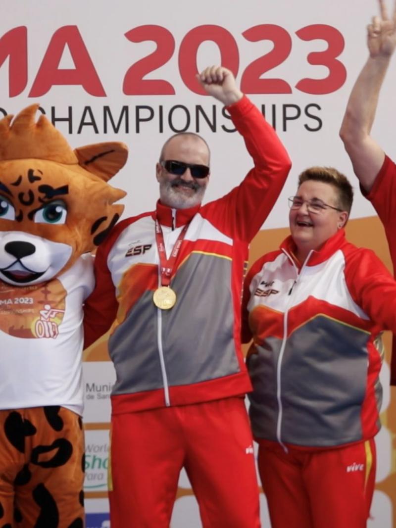 Three women and three men on a podium with a mascot