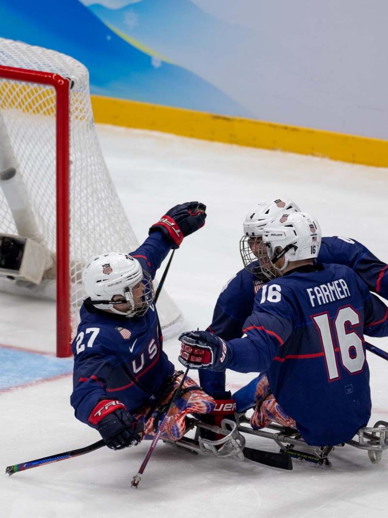 Three USA Para ice hockey players celebrating a goal