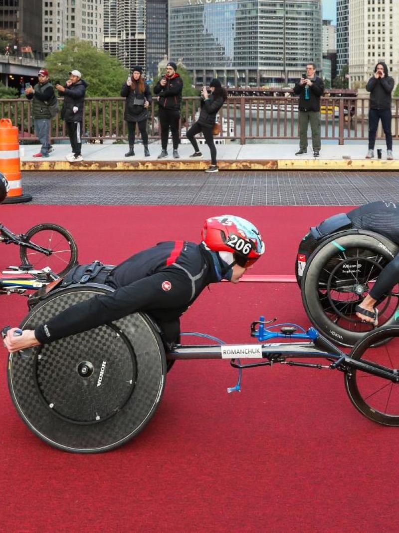Three male wheelchair racers in a street marathon