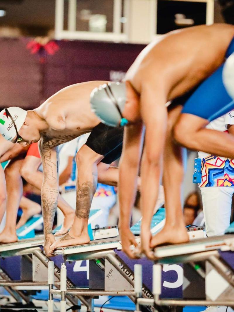 Six men on starting blocks of a Para swimming race