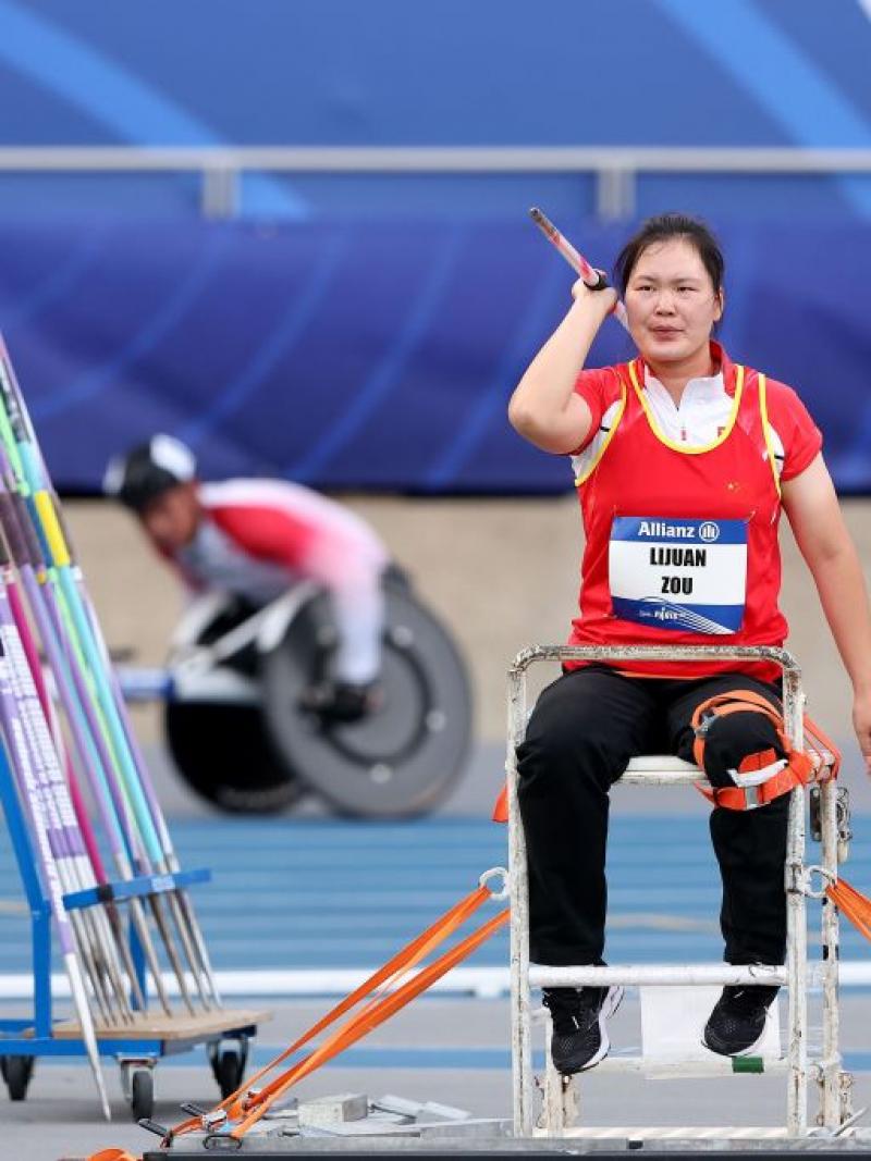 A female seated javelin thrower in a Para athletics competition
