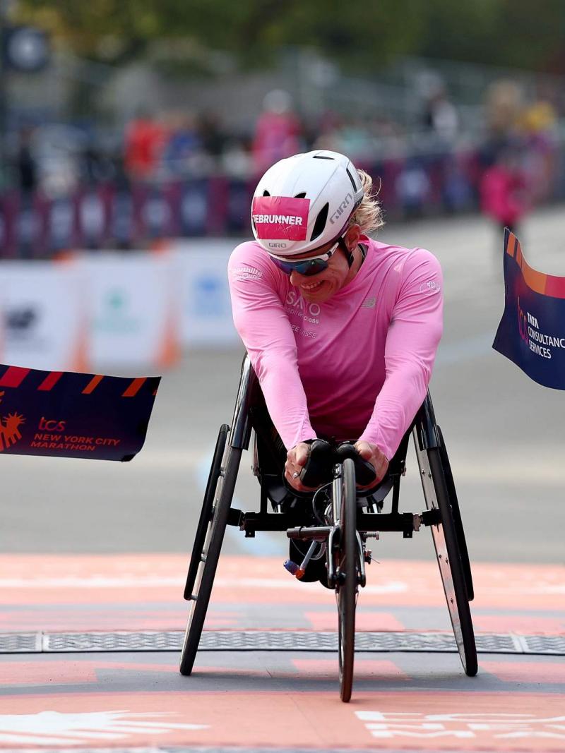 A female wheelchair racer crossing the finish line in a street marathon