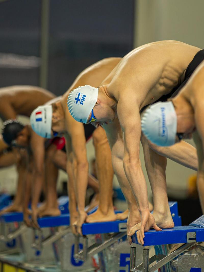 Seven Para swimmers on the starting block before a race