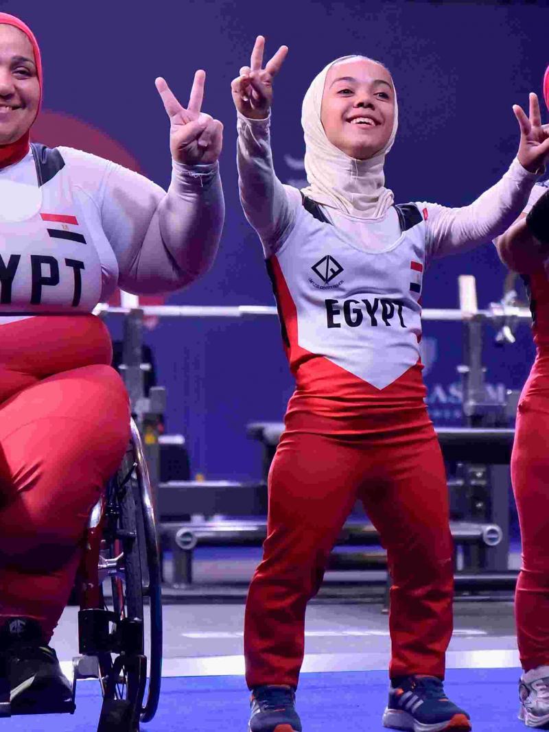Women powerlifters celebrate.