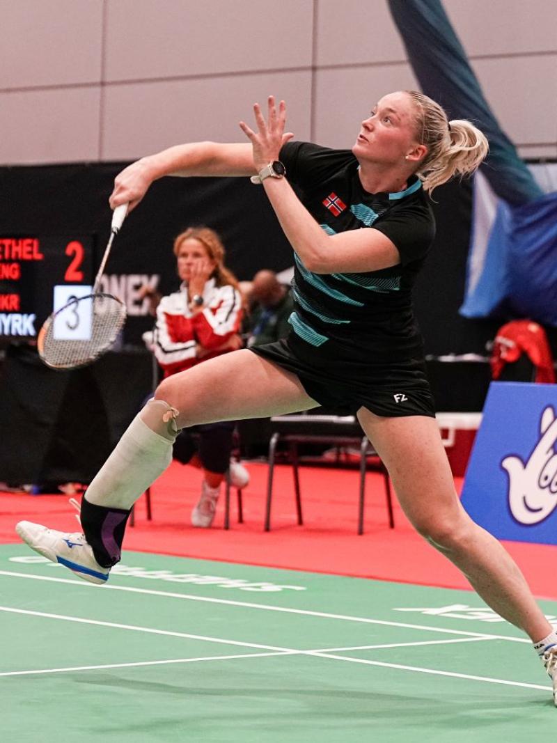 A female Para badminton player competes in a tournament.