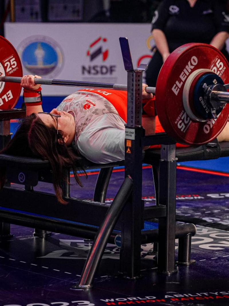 A woman on a bench press in Para powerlifting competition