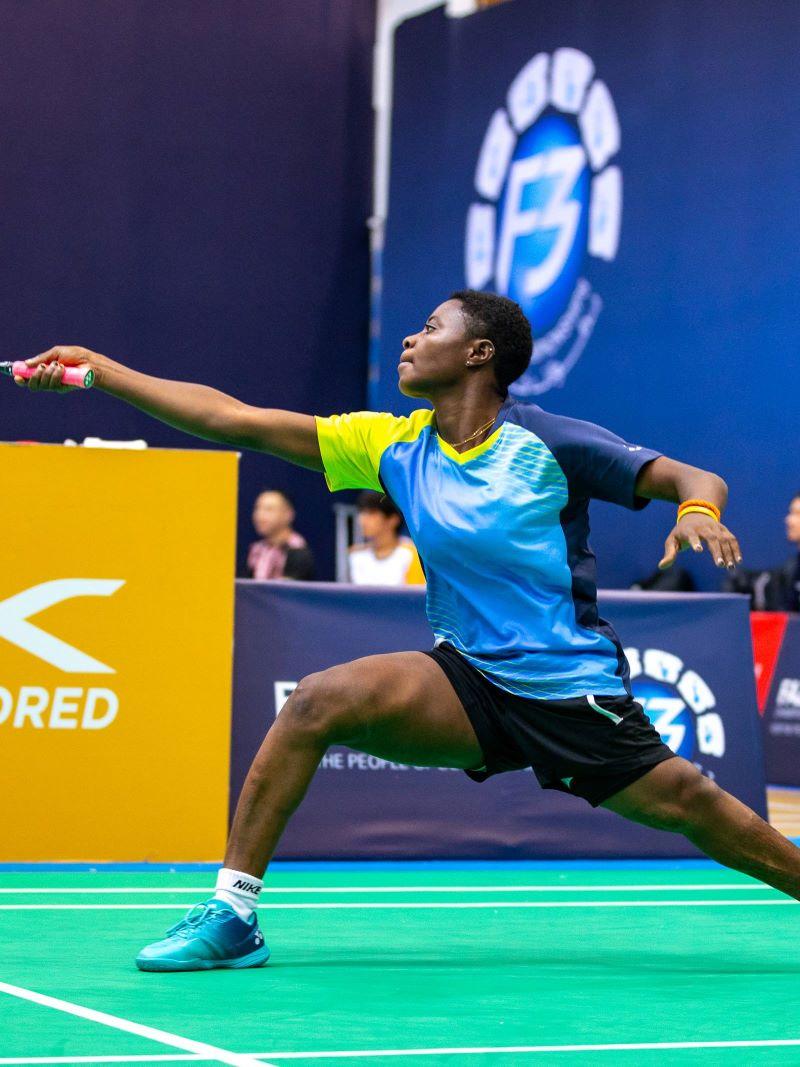A female badminton athlete in action.