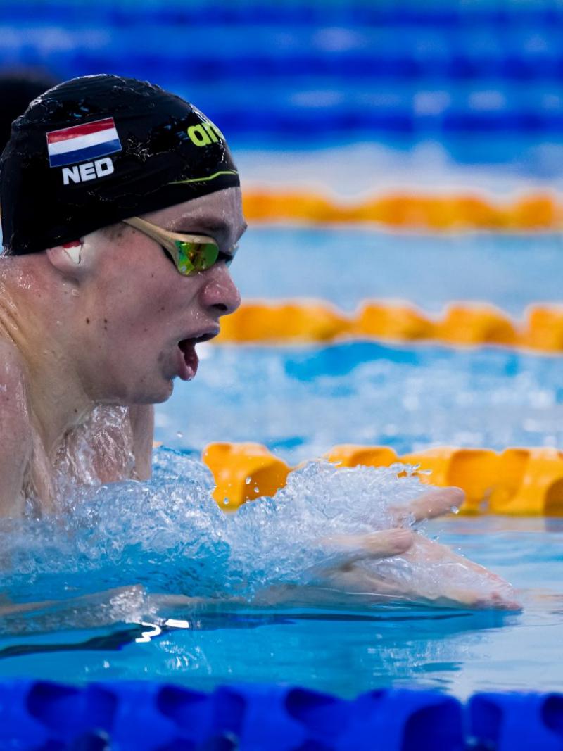 A male swimmer with a cap with the Dutch flag