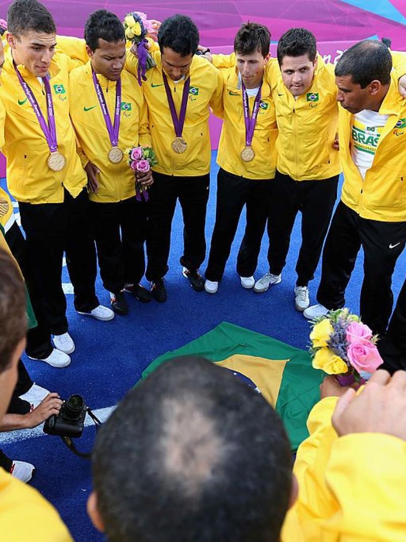 Blind football players and staff form a circle after receiving their gold medals at the London 2012 Games.
