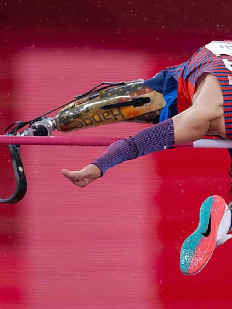 Ezra Frech jumps backwards over the high bar displaying his prosthetic leg