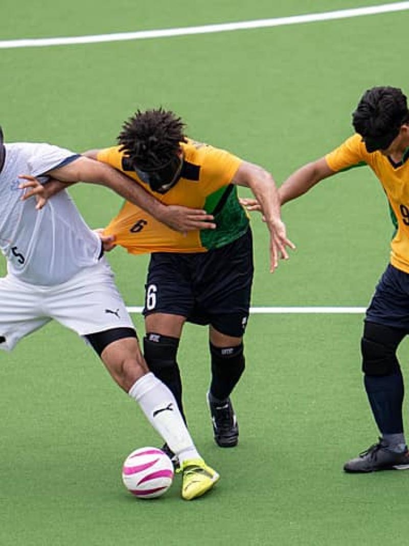 three blind footballers fight for the ball 