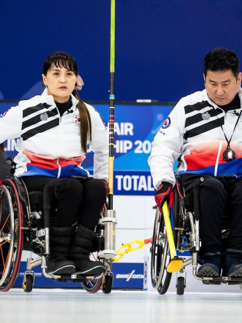 A male and a female wheelchair curlers take part in a competition