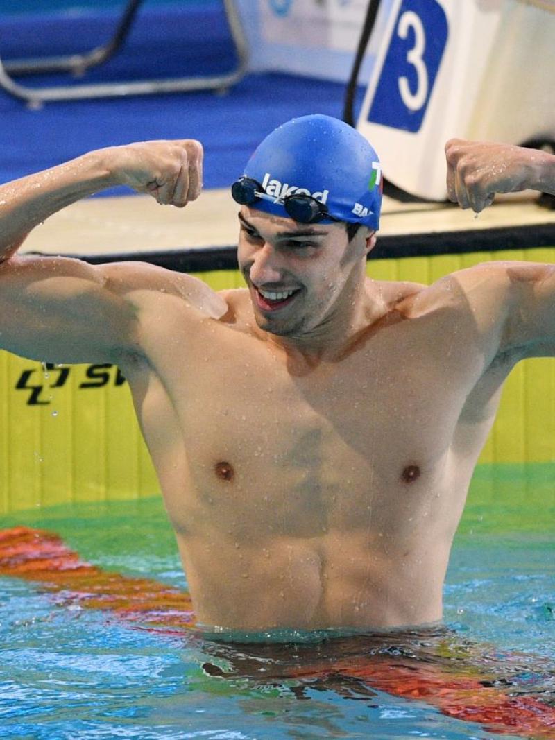 A male swimmer showing his arms in the pool