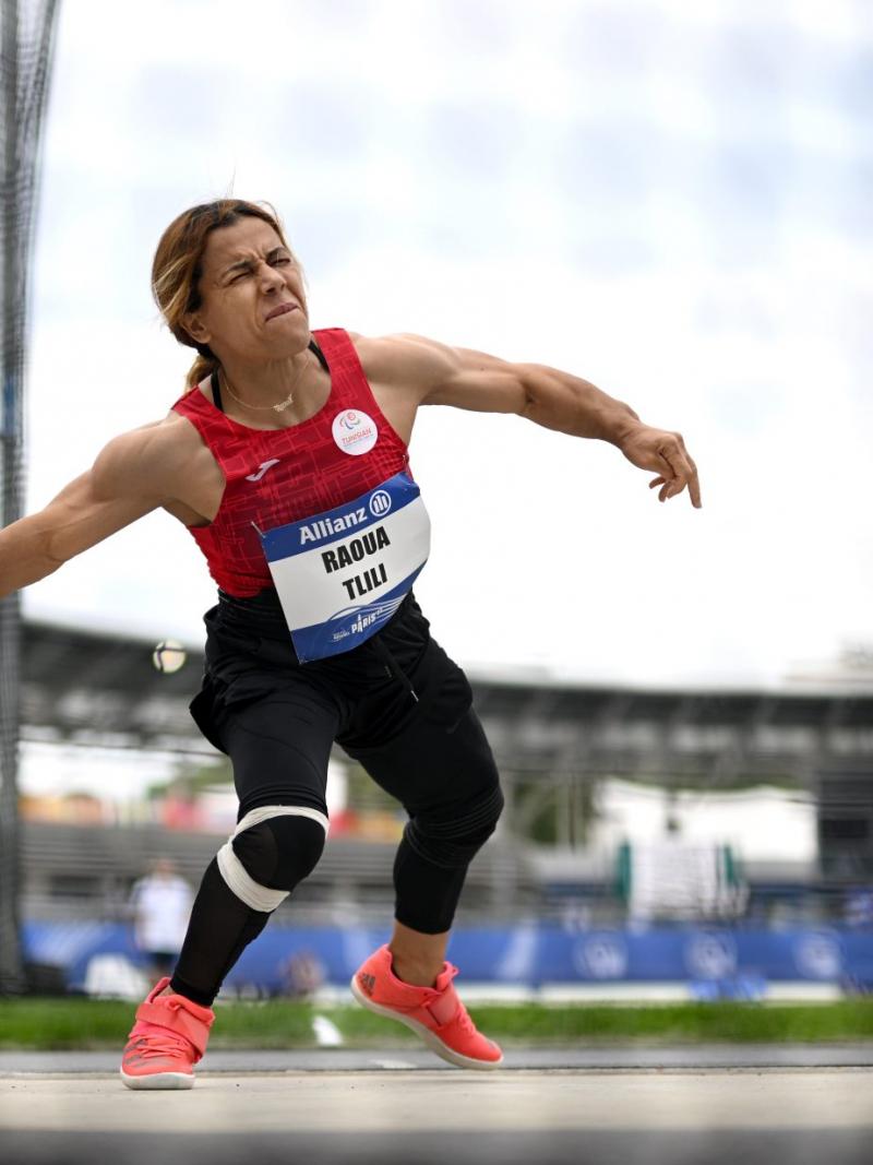 A short stature woman competing in the discus throw