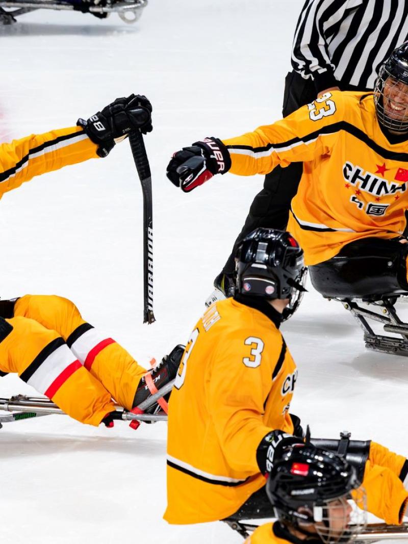 Three Chinese Para ice hockey players celebrating in a game
