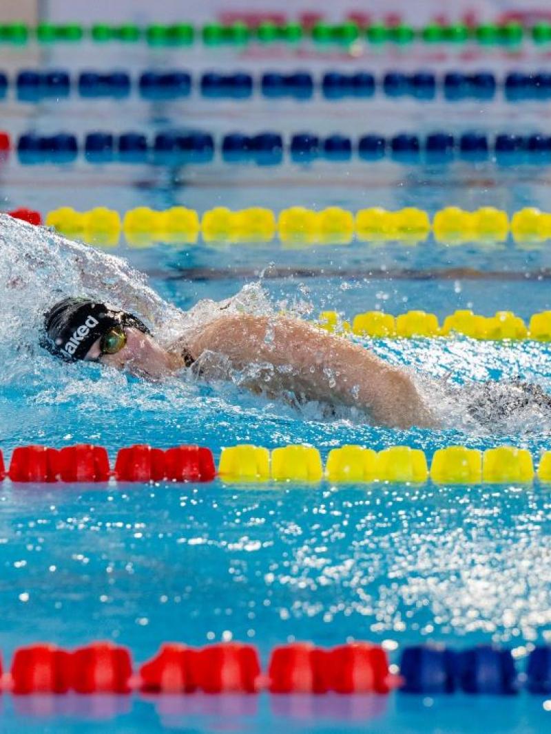 A female swimmer competing in the freestyle stroke