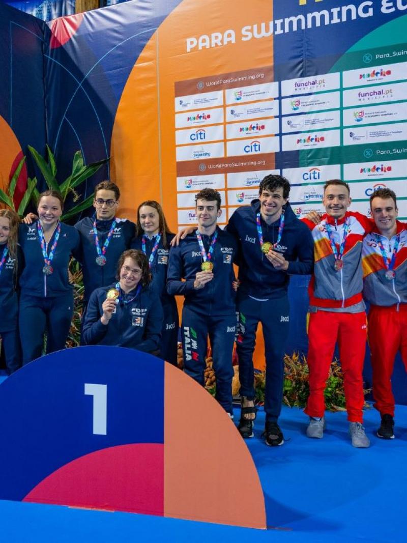 A podium of a relay swimming race with 12 athletes
