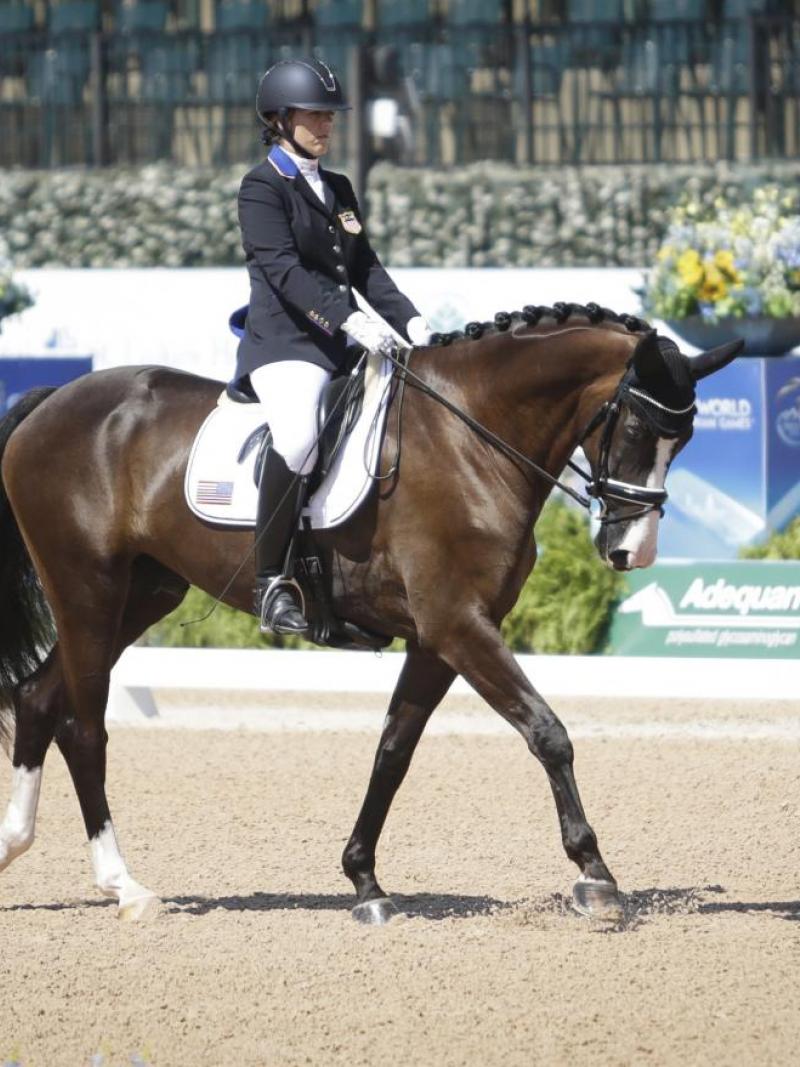 A female Para equestrian athlete rides a horse