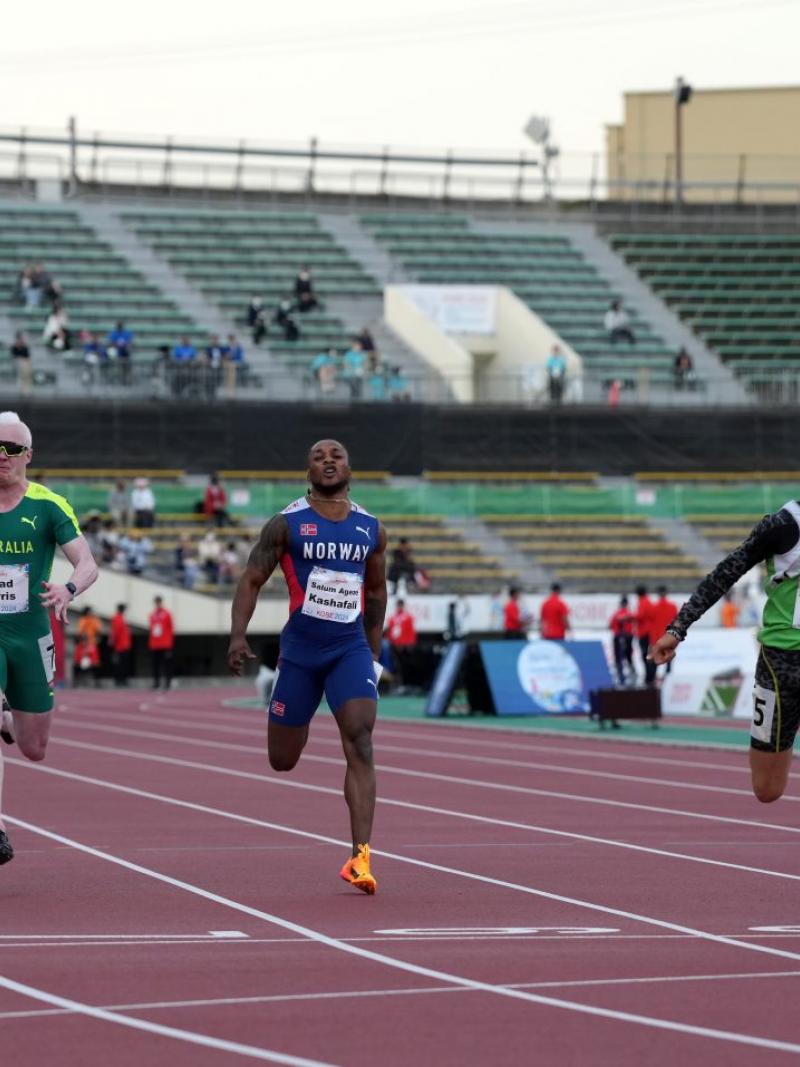 A man crossing the finish line in an athletics race ahead of five competitors