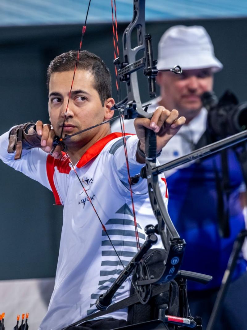 A male Para archer aims at a target during competition