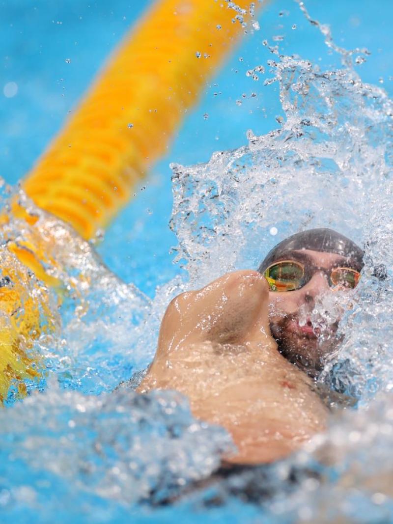 An armless man swimming backstroke