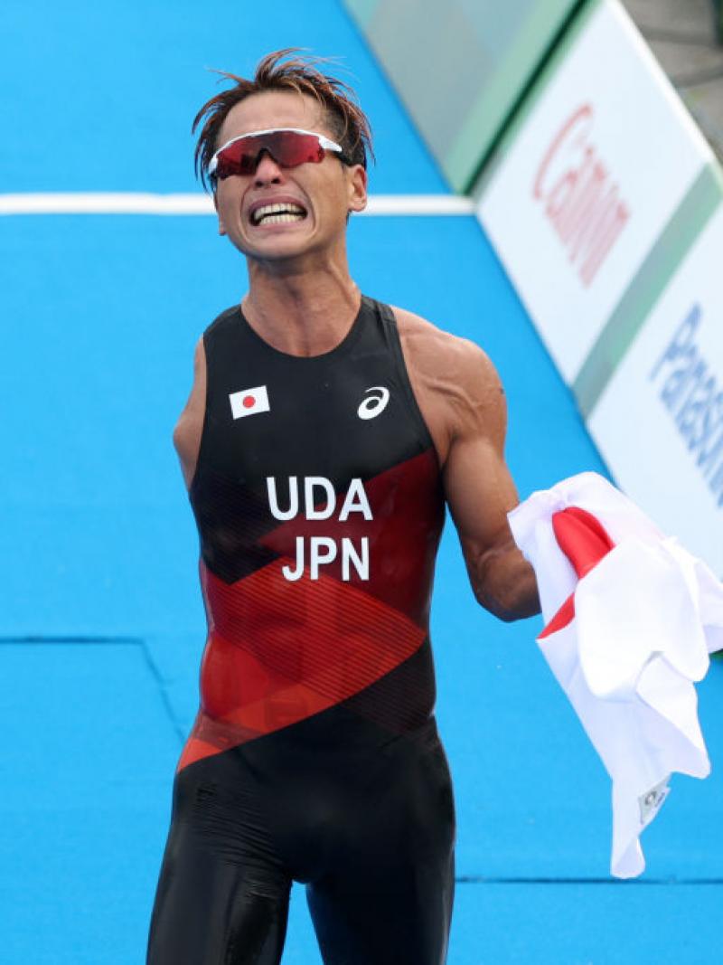 A male Para triathlon athlete reacts as he crosses the finishline