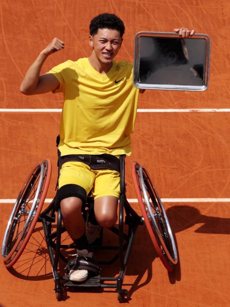 A male wheelchair tennis player poses for a photo after winning the 2024 French Open