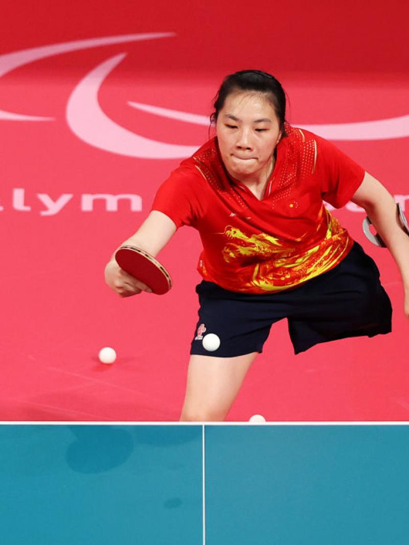 A female Para table tennis player competes using a cane