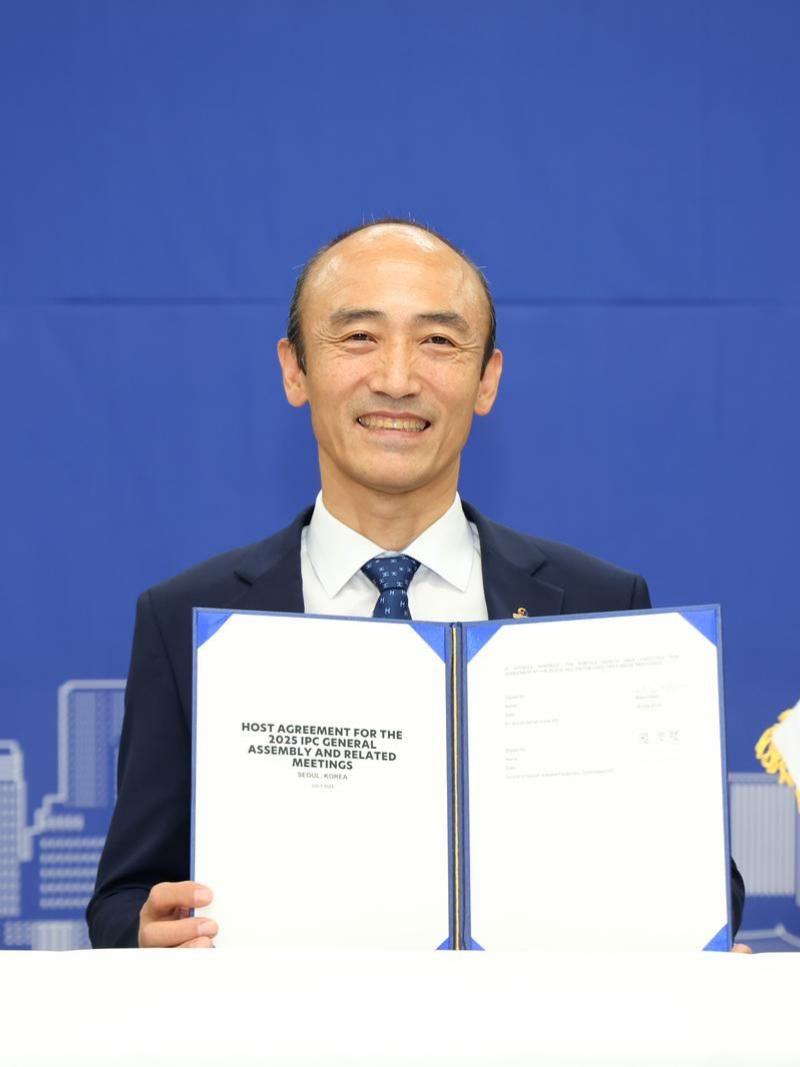 Korea Paralympic Committee President Jin-owan Jung holds a document titled "Host Agreement for the 2025 IPC General Assembly"