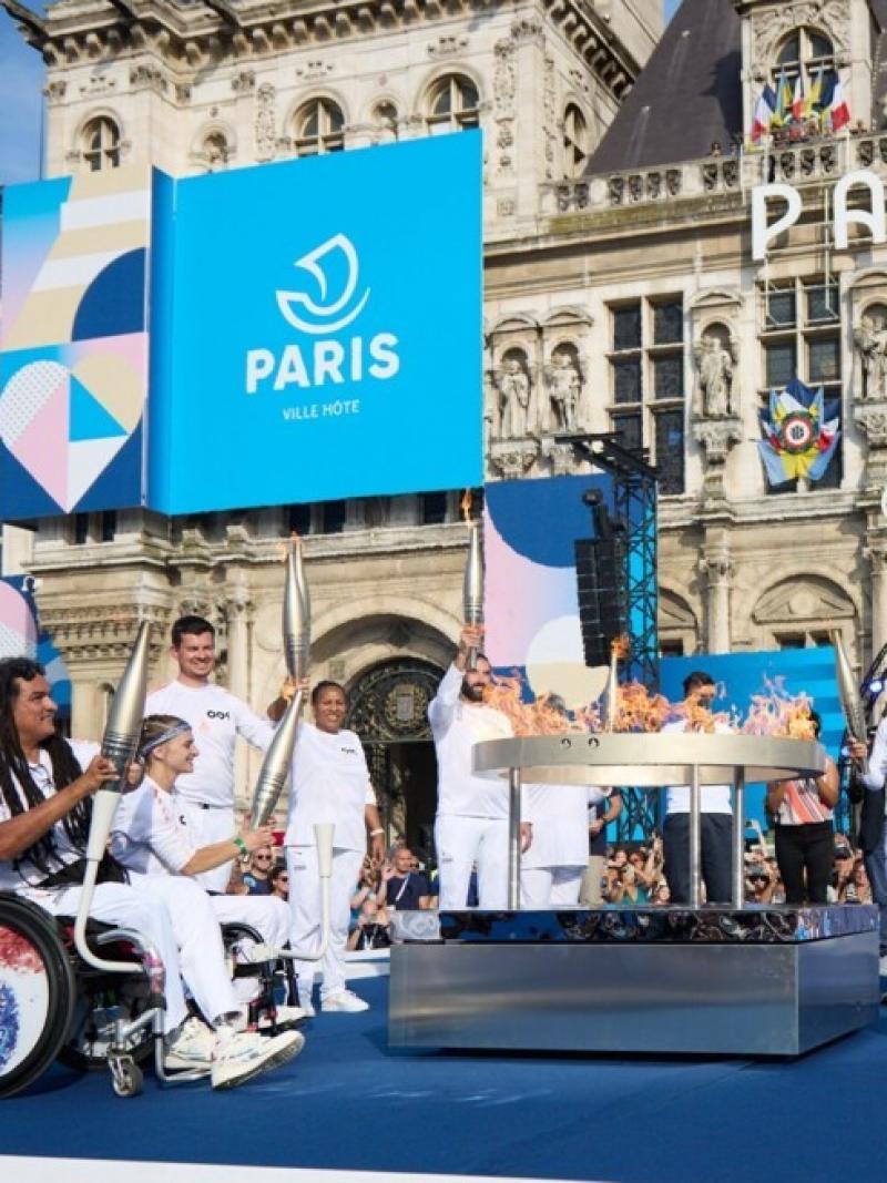 Torchbearers stand around the Paralympic flame in the centre of Paris