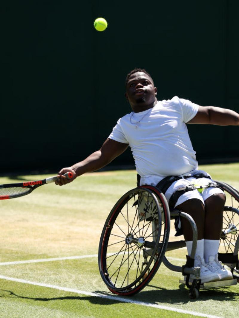 Wheelchair tennis player Donald Ramphabi prepares to hit the tennis ball